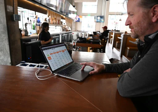 small businesses financial challenges Laptop with financial or scheduling software displayed on screen.