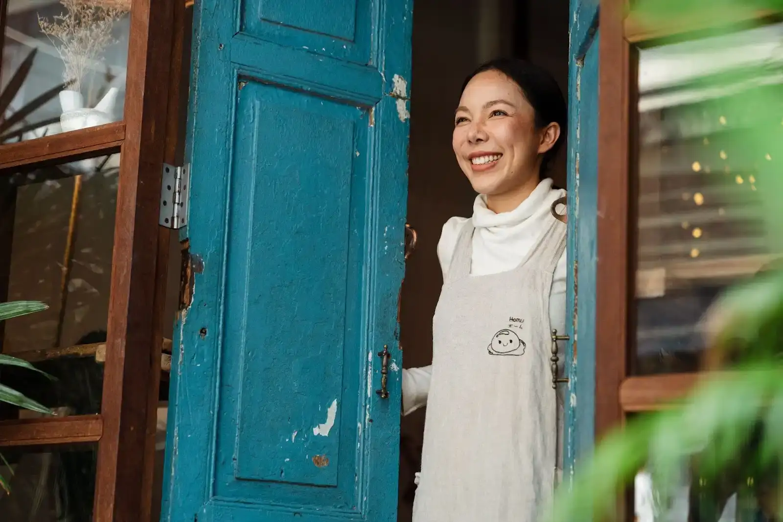 Woman smiling at doorway, representing cash flow lending solutions.