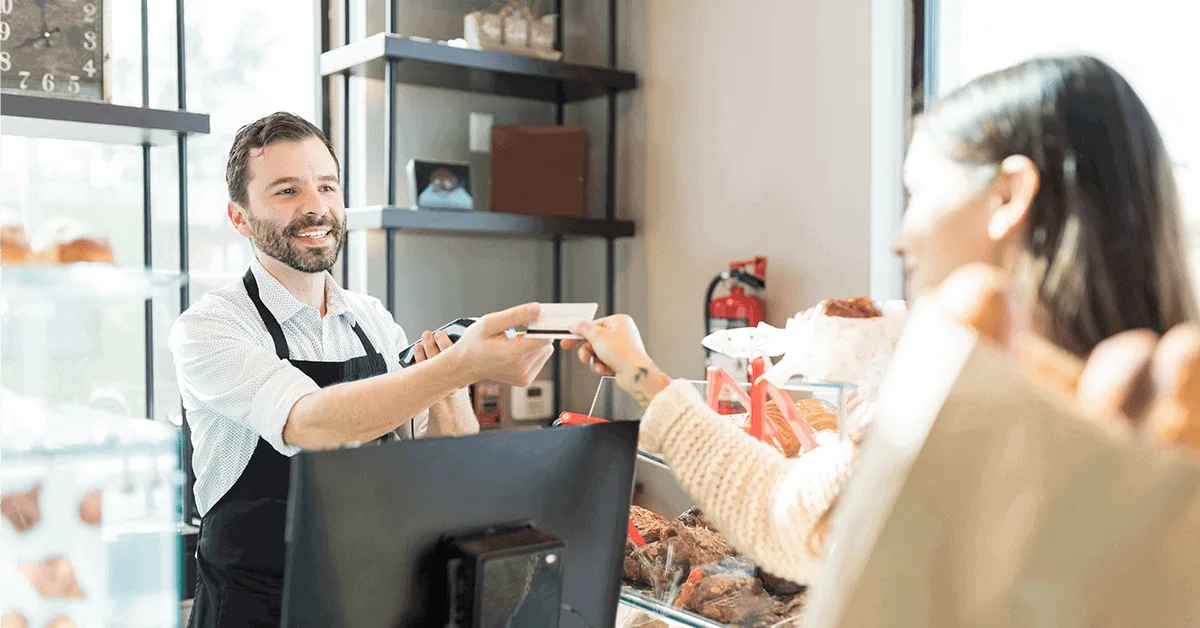 Friendly cashier assisting customer with payment at a retail store.