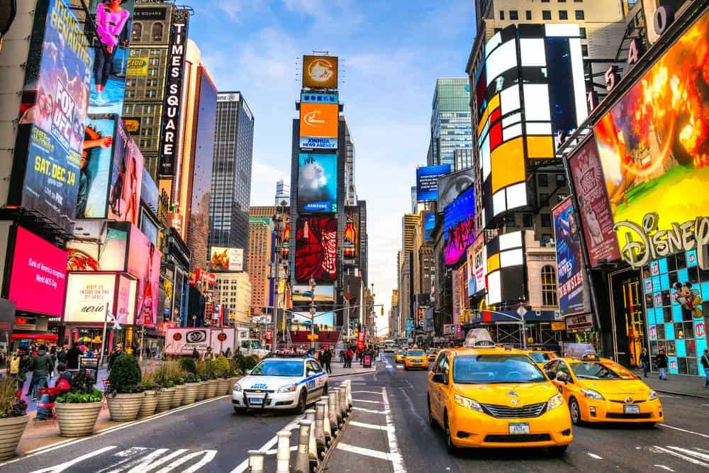 Bright Times Square with taxis and billboards in New York City.