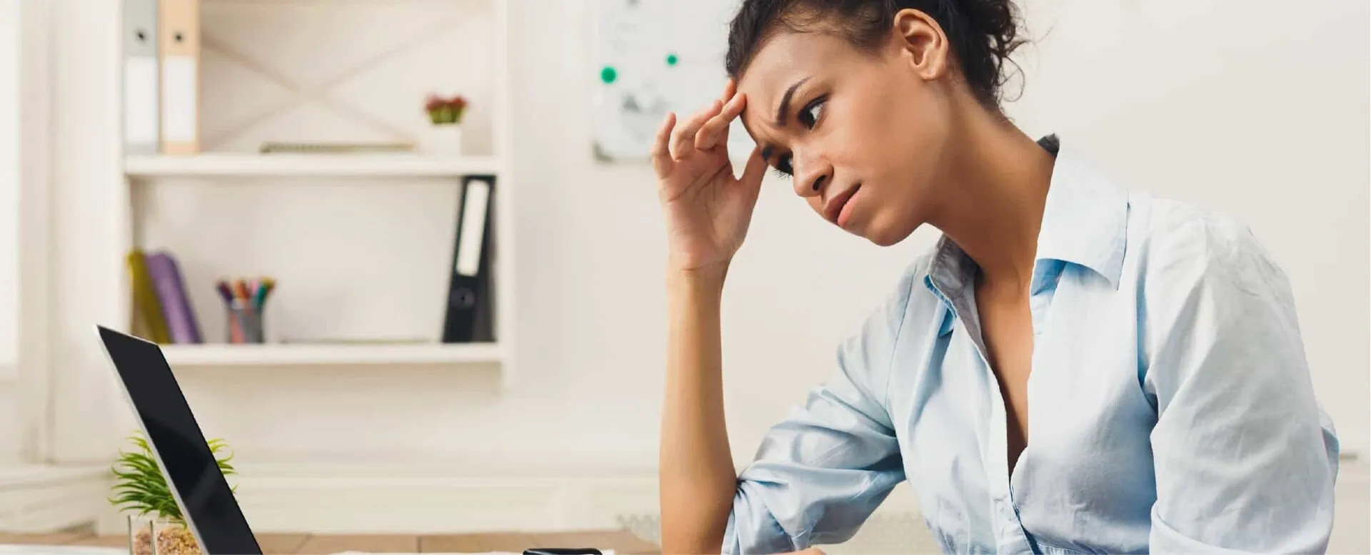 Frustrated woman working on a laptop, feeling stressed about business challenges during COVID-19.