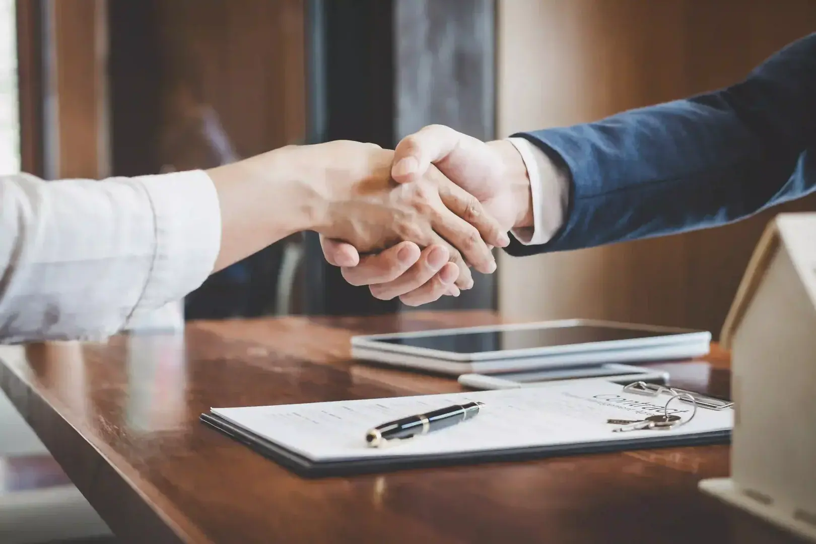 Business owner shaking hands with a direct business lender after reviewing financing documents