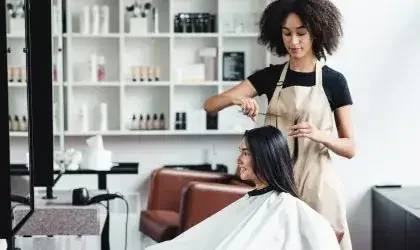 Young-woman-enjoying-haircut-at-beauty-salon-with-black-master-scaled-r9vhl4y991ucop1t8egqnttappvfet8274dx9zj5qc