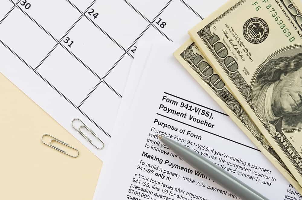 Small business quarterly tax payment form with money and calendar.