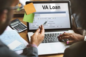 Person filling out VA loan application on laptop for small business funding.