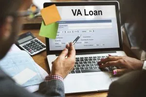 Person filling out VA loan application on laptop for small business funding.
